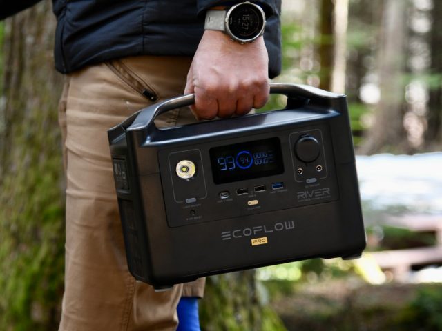 Mann mit Shorts trägt EcoFlow Powerstation durch den Wald