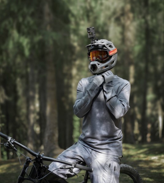 Mountainbiker mit Integralhelm und DJI Action im Wald