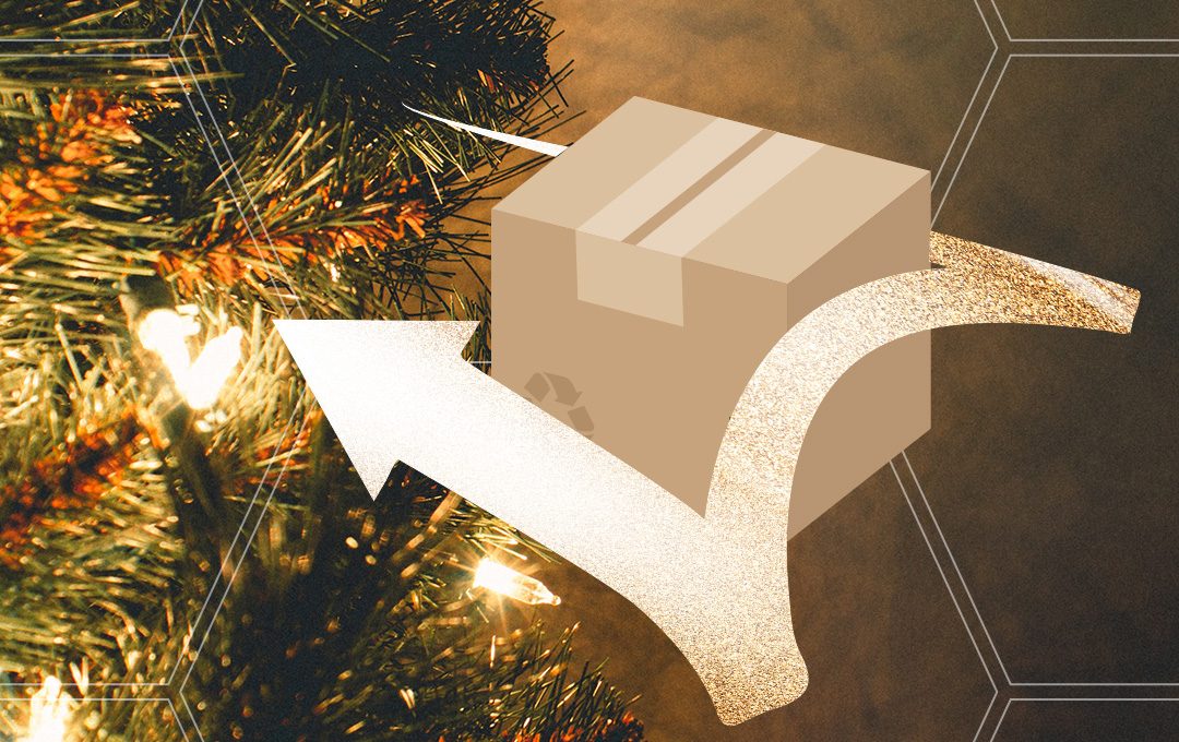 Paket mit Pfeil vor weihnachtlich goldener Deko im Hintergrund