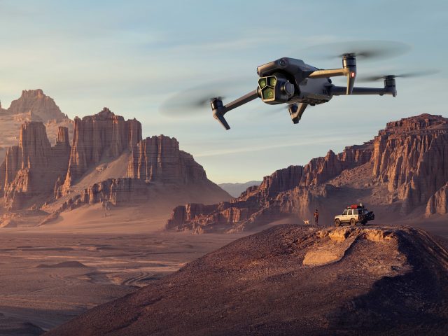 DJI Mavic 3 Pro Drohne schwebt über Felsenlandschaft mit Geländewagen