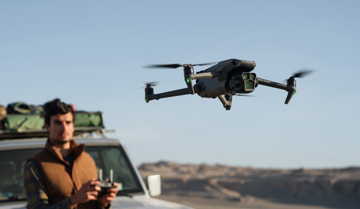 DJI Mavic 3 Pro vor Drohnenpliot an Jeep in Prärielandschaft