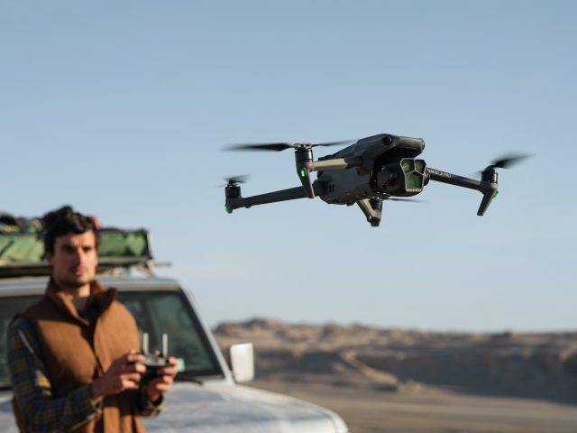 DJI Mavic 3 Pro vor Drohnenpliot an Jeep in Prärielandschaft
