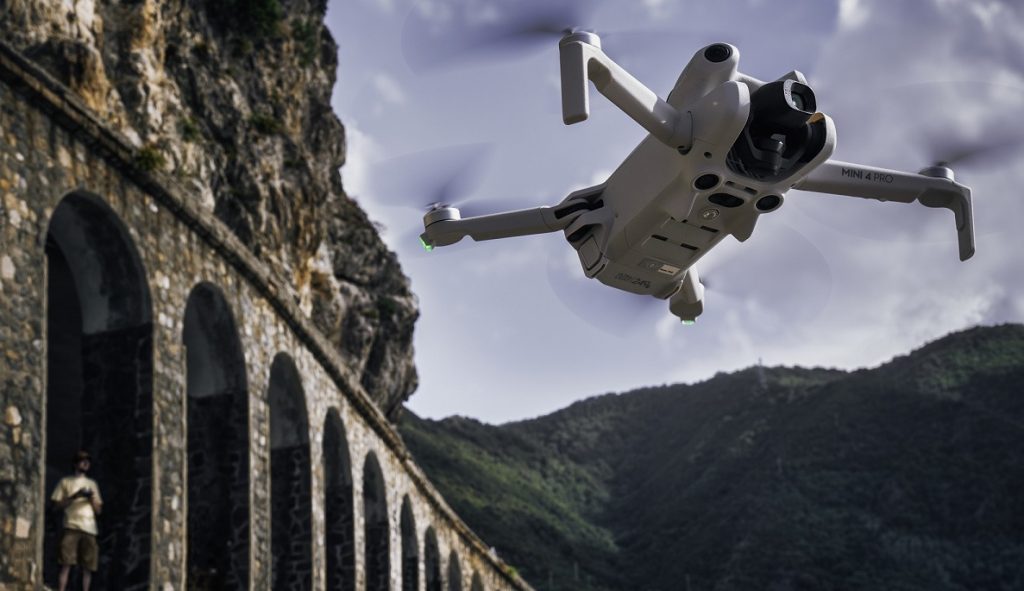 DJI Mini 4 Pro Drohne schwebt vor alter Brückenkulisse