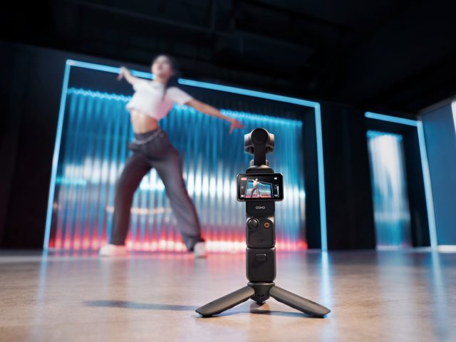 DJI Osmo Pocket 3 mit Stativ filmt tanzende Frau vor Neonhintergrund