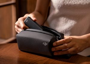 Frauenhand steckt DJI Osmo Pocket 3 in Zubehörtasche