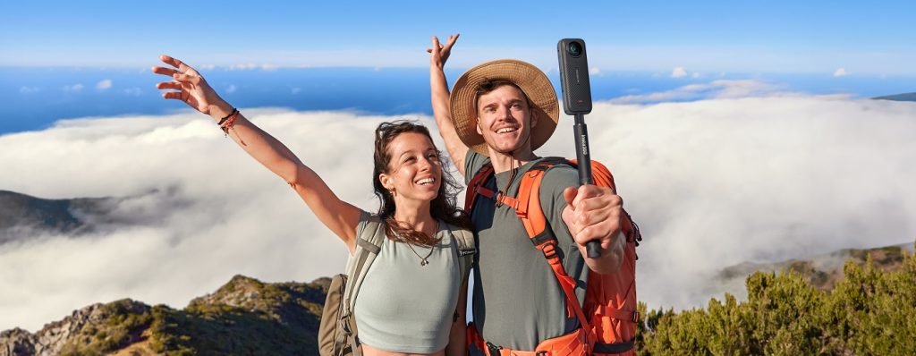 Paar macht Selfie auf Berggipfel mit Insta360 X4