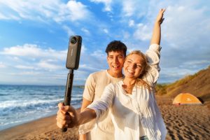 Paar am Strand macht fröhliches Selfie mit Insta360 X4