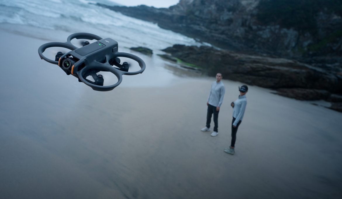 DJI Avata 2 Drohne schwebt über Strand mit zwei Menschen