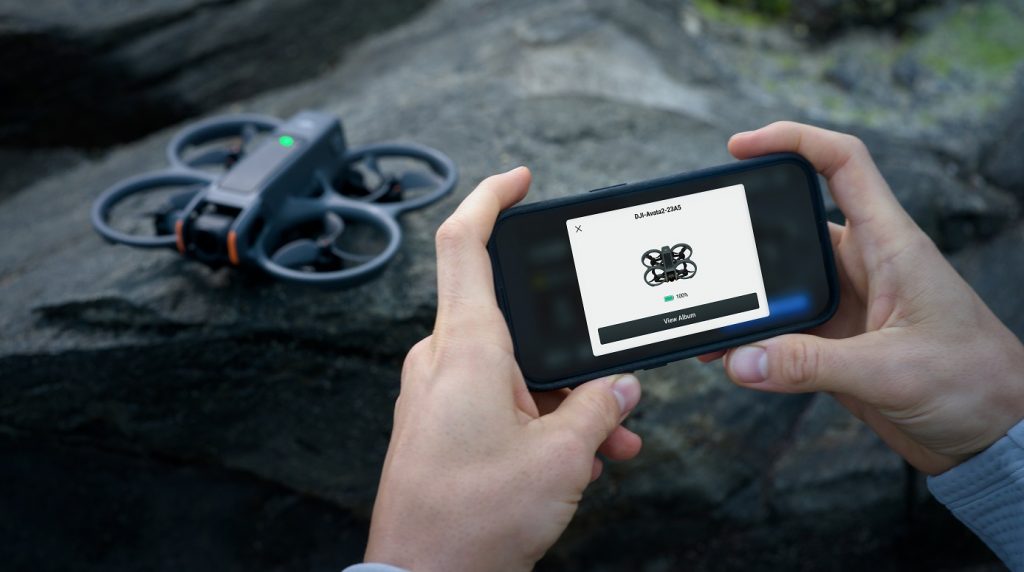 Hände halten Smartphone mit DJI Avata App und Drohne im Hintergrund